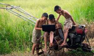 children on farm with laptop