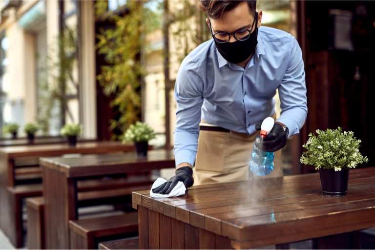 waiter in mask cleaning table