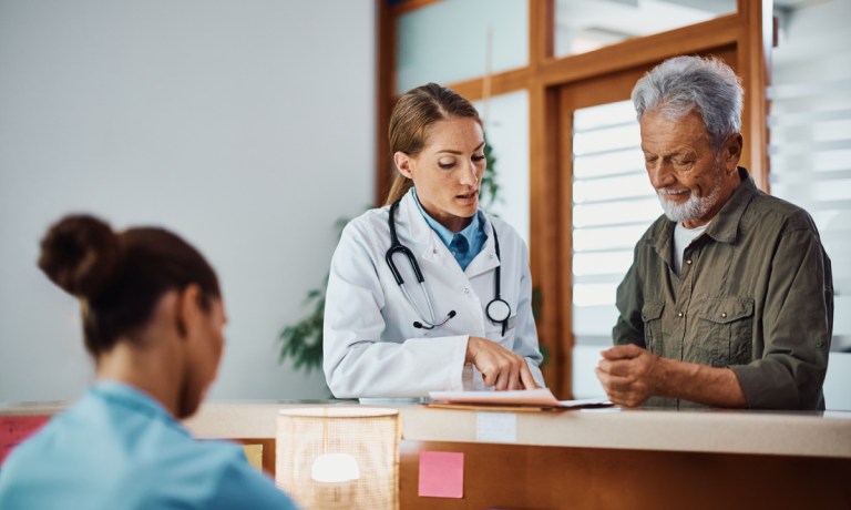 doctor with patient and paperwork