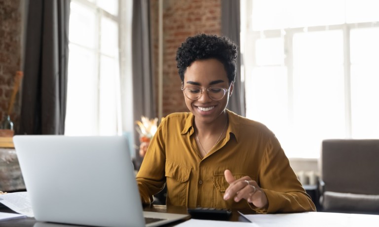 woman working on laptop and calculator