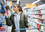 woman checking price in grocery store