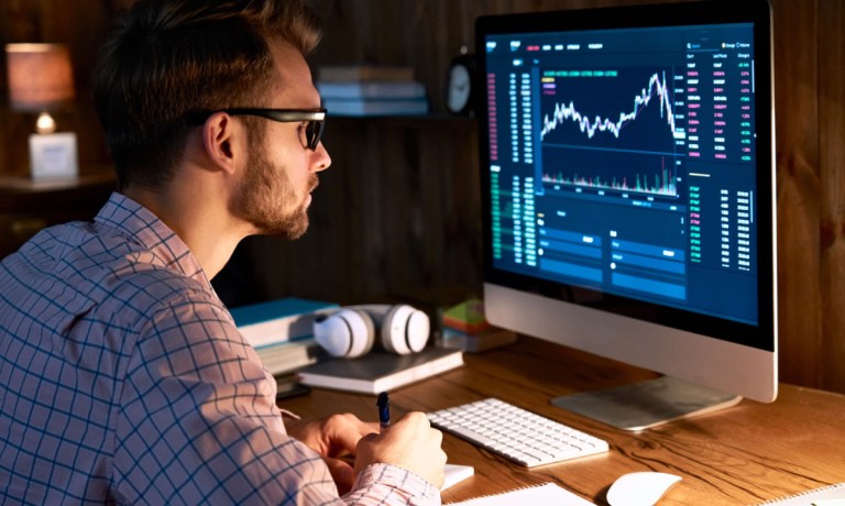 man watching stock market on screen