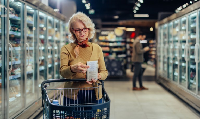 woman checking price in grocery store