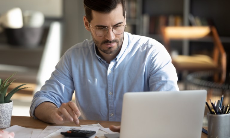 man with laptop and calculator