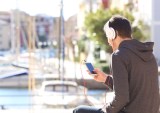 young man streaming audio on smartphone