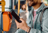 man using mobile wallet on bus