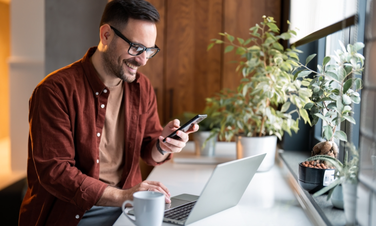 man with phone and laptop