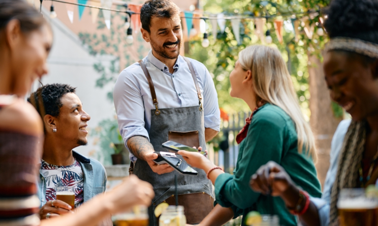 woman paying at restaurant with mobile wallet