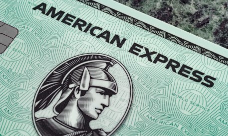 a close up of a green american express card with a woman ' s face on it